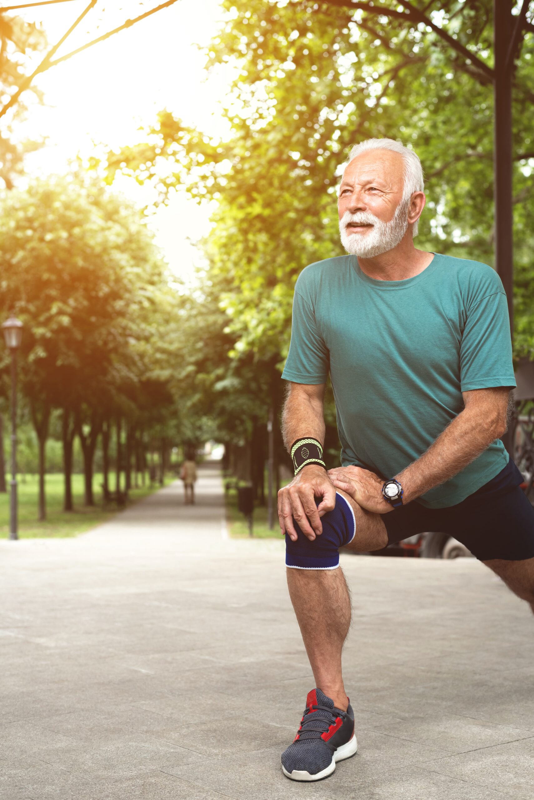 Senior man stretching legs before workout at park